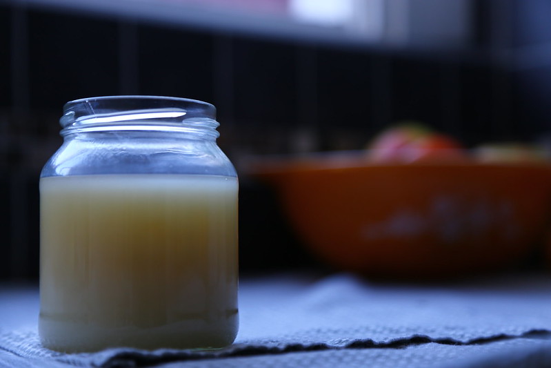 Homemade beef tallow in a small jar on a kitchen counter.